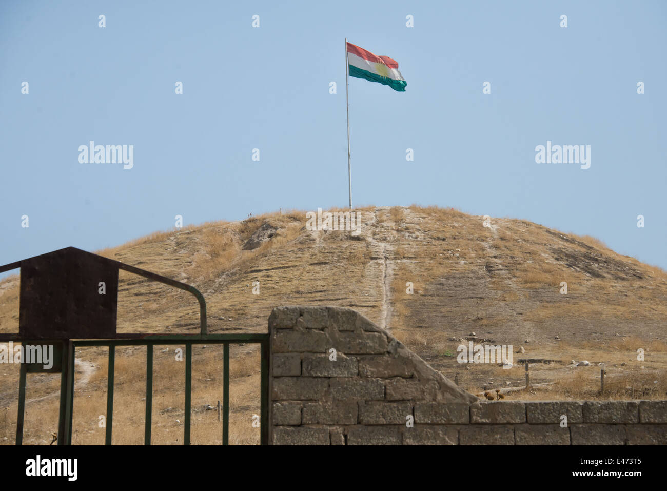 Un drapeau flotte au sommet d'une colline près de la ville de Duhok, province de Ninive, Kurdistan irakien, le 6 juin 2014 Banque D'Images