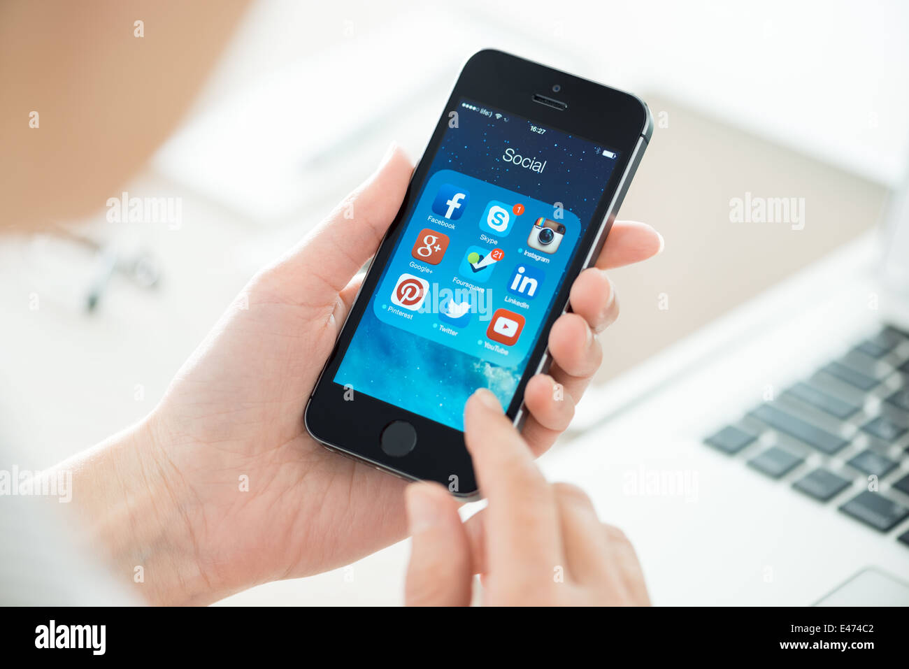 Femme à la recherche sur les applications de médias sociaux sur un tout nouveau Apple iPhone 5S noir Banque D'Images