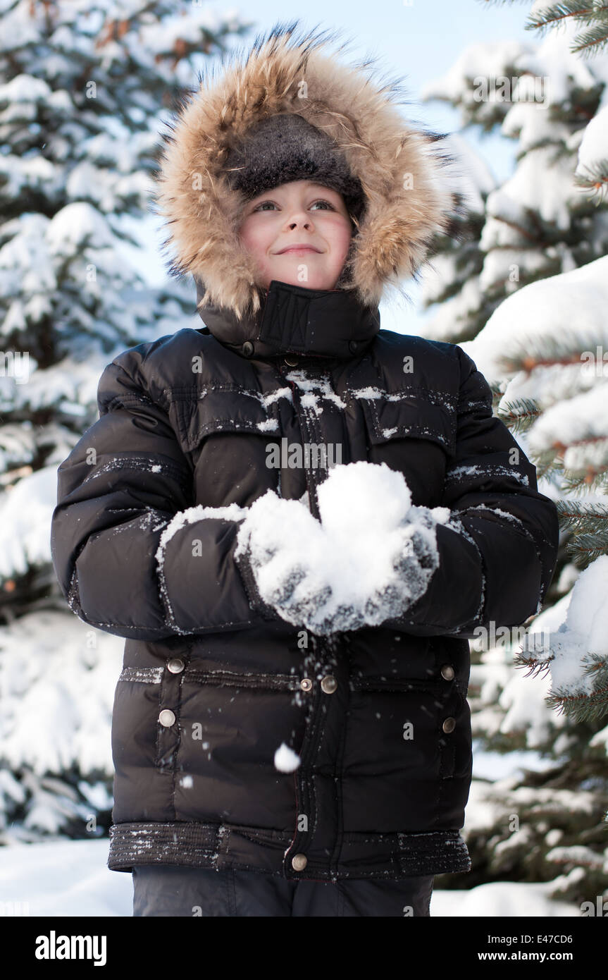 Garçon enfant un hiver froid du nord de la Russie le parc forestier de veste de neige couverte de neige blanc étudiant à pied de l'air frais man portrait ch Banque D'Images