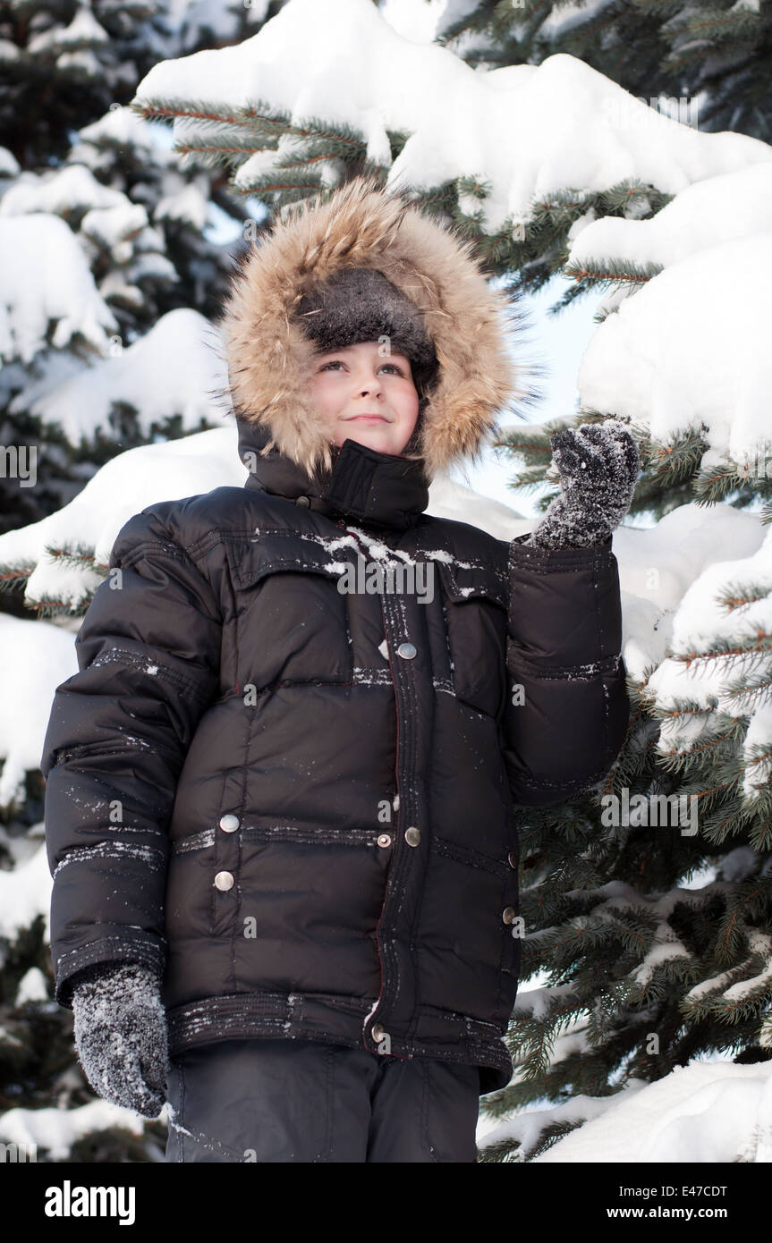 Garçon enfant un hiver froid du nord de la Russie le parc forestier de veste de neige couverte de neige blanc étudiant à pied de l'air frais man portrait ch Banque D'Images