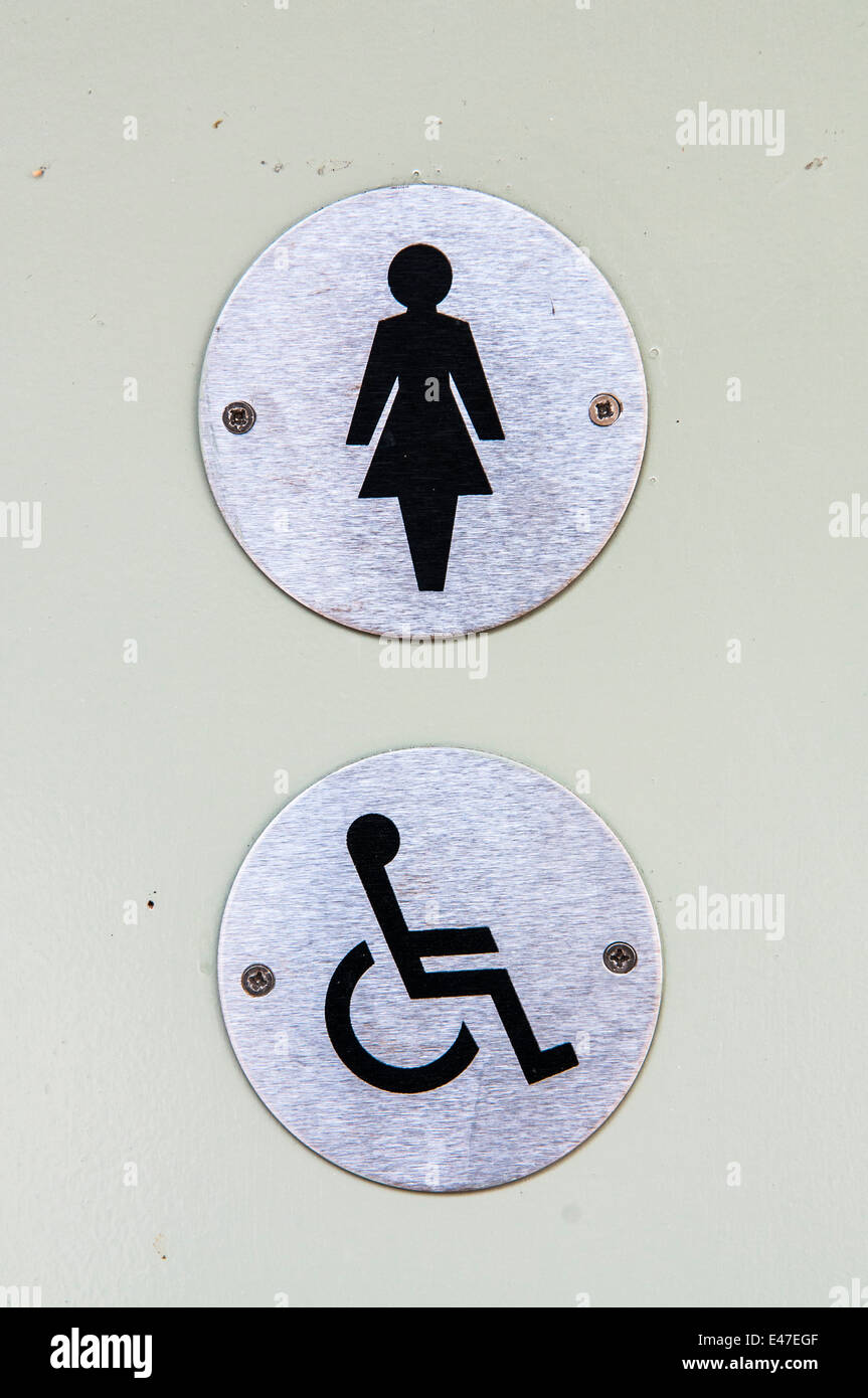 Les panneaux pour un mesdames et toilettes pour handicapés sur une porte Banque D'Images