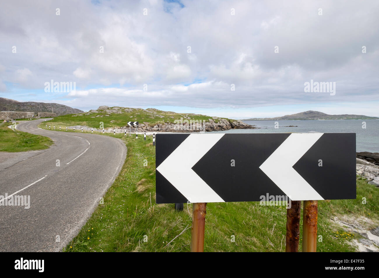 Chevron noir et blanc avertissement signe sharp bend lefthand sur une route côtière sur South Uist Outer Hebrides Western Isles Scotland UK Banque D'Images