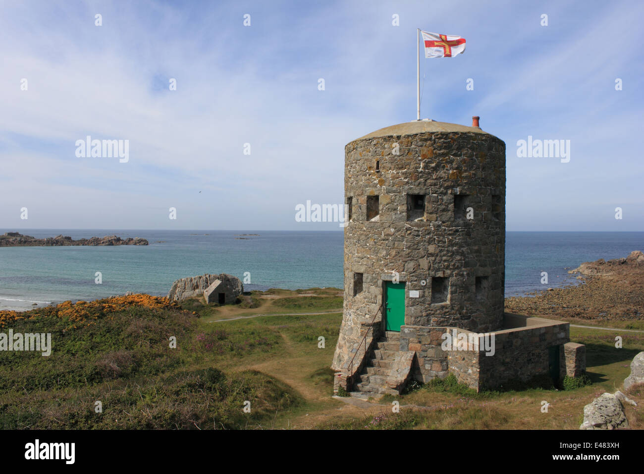 Une échappatoire tower sur la côte de Guernesey Guernesey avec le flag flying Banque D'Images