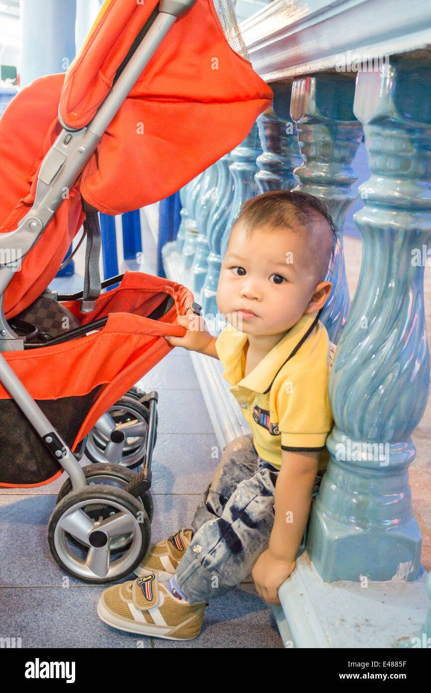 Asian cute boy posent avec poussette de bébé, stock photo Banque D'Images