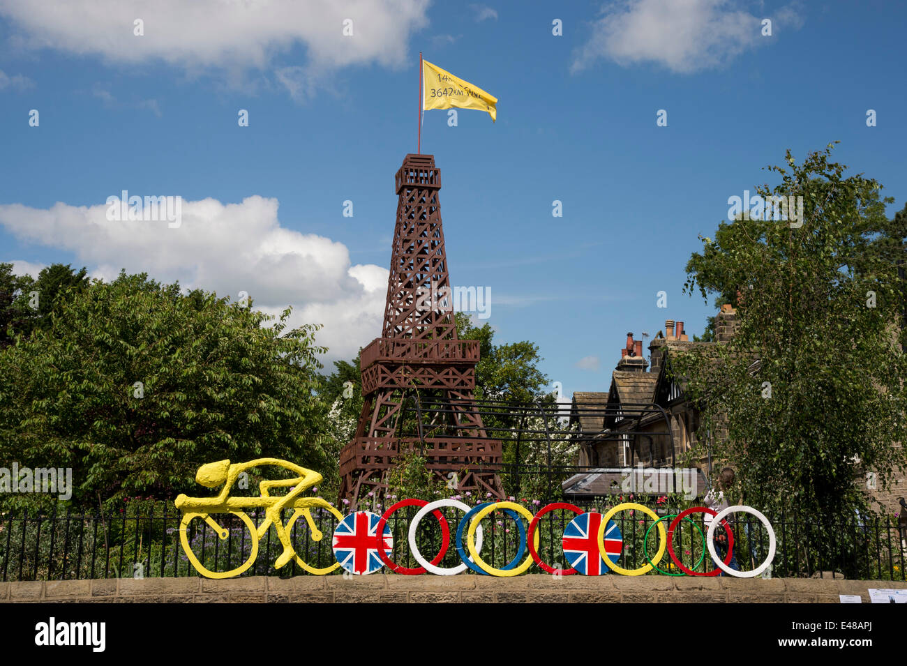 Sous le ciel bleu, la Tour Eiffel en bois avec un drapeau jaune et de modèle fixe cycliste de jardin clôture, construit pour célébrer le tour dans le Yorkshire - Burley-In-Wharfedale, England, UK. Banque D'Images