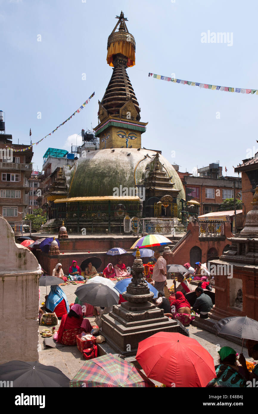 Le Népal, Katmandou, Stupa Kathesimbhu,femme tibétaine rituel puja bouddhiste entreprise sous les parasols Banque D'Images