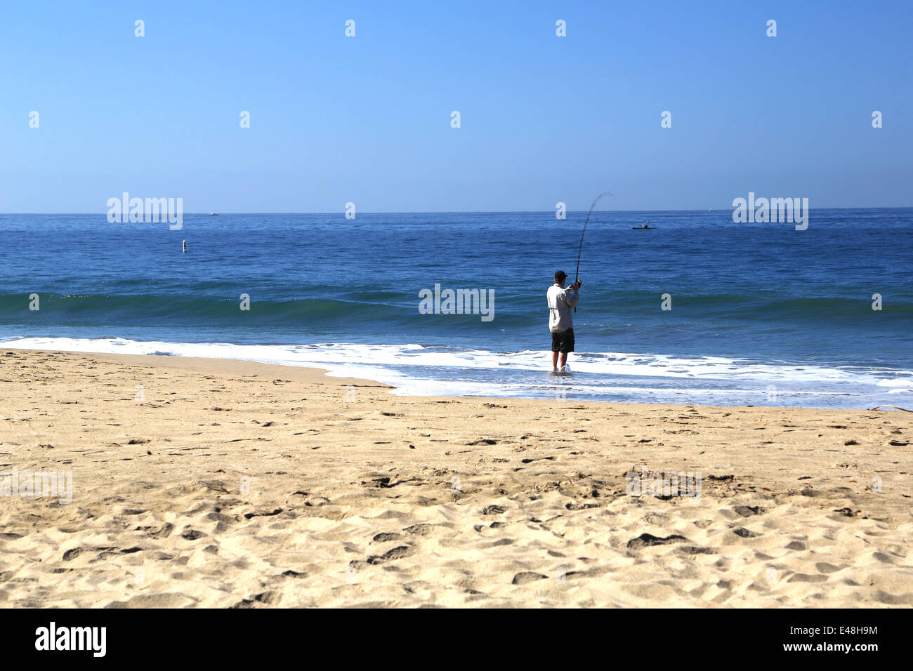 L'homme pêche sur la plage de Seabright, sur East Cliff à Santa Cruz, l'Océan Pacifique Banque D'Images