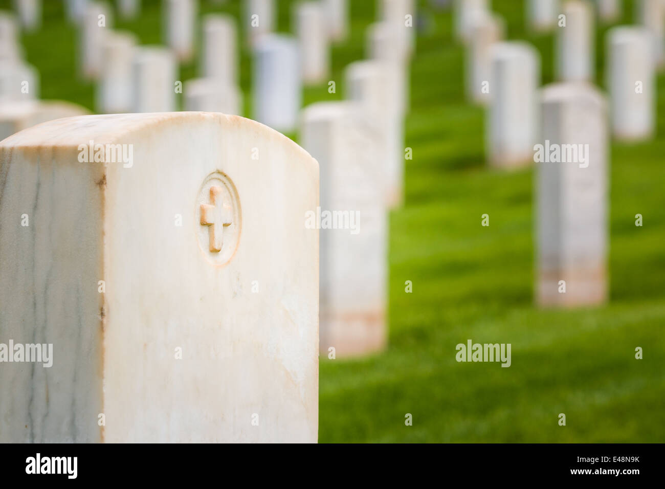 Les rangées de pierres tombales dans un cimetière militaire avec l'herbe de printemps vert vif Banque D'Images