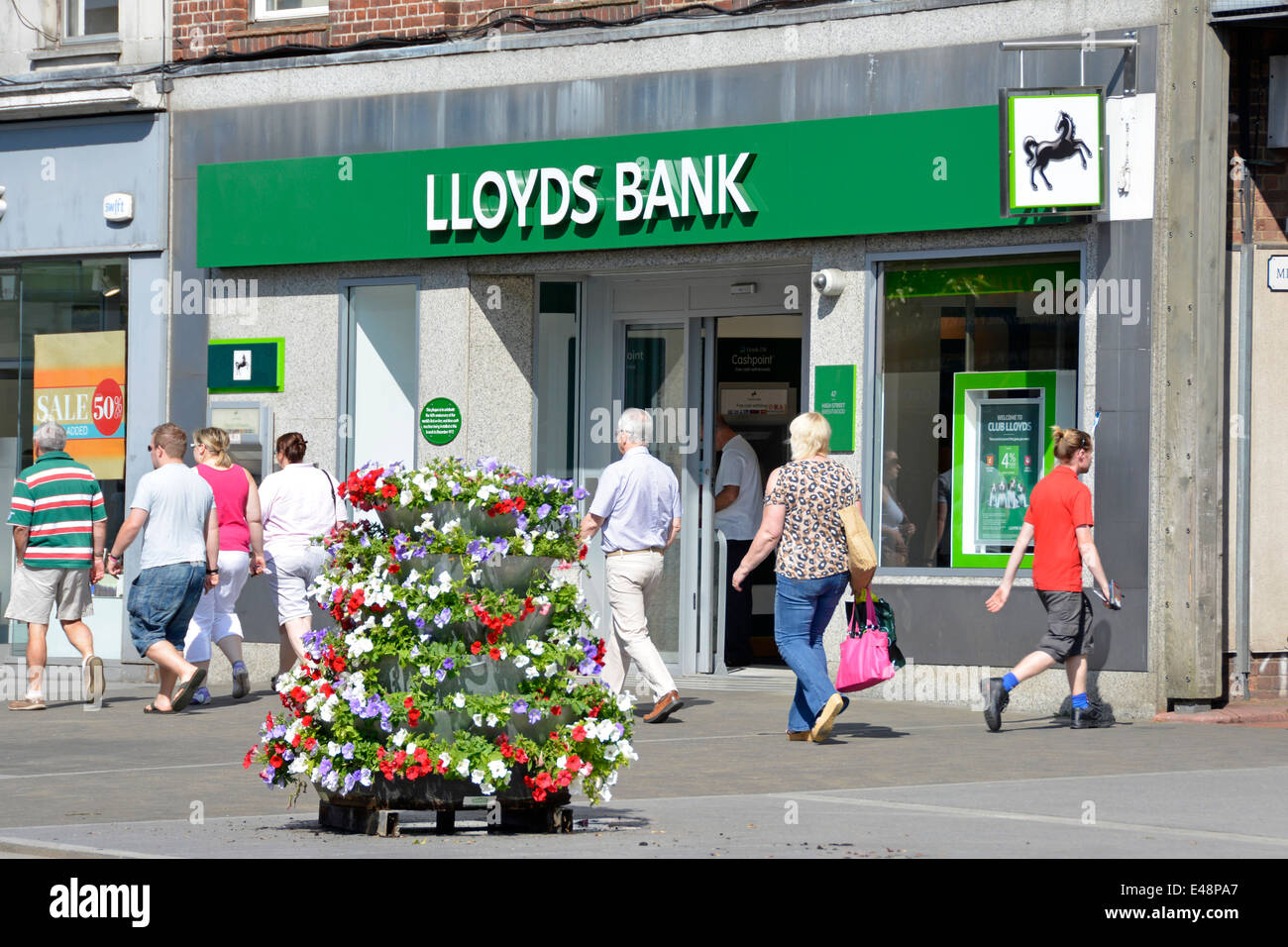 La Banque Lloyds High Street Brentwood Essex England UK Branch trottoir affichage floral & plaque murale pour la première ligne, en temps réel, sur le distributeur automatique de billets Banque D'Images