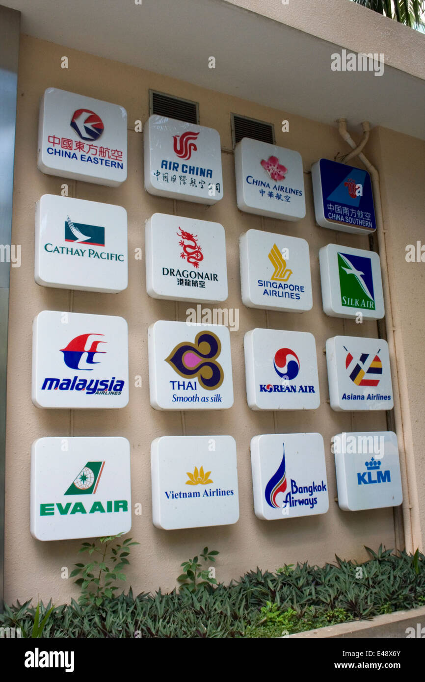 Signe avec la compagnie aérienne asiatique logos sont attachés à un mur dans une agence de voyage à Phnom Penh, Cambodge. Banque D'Images