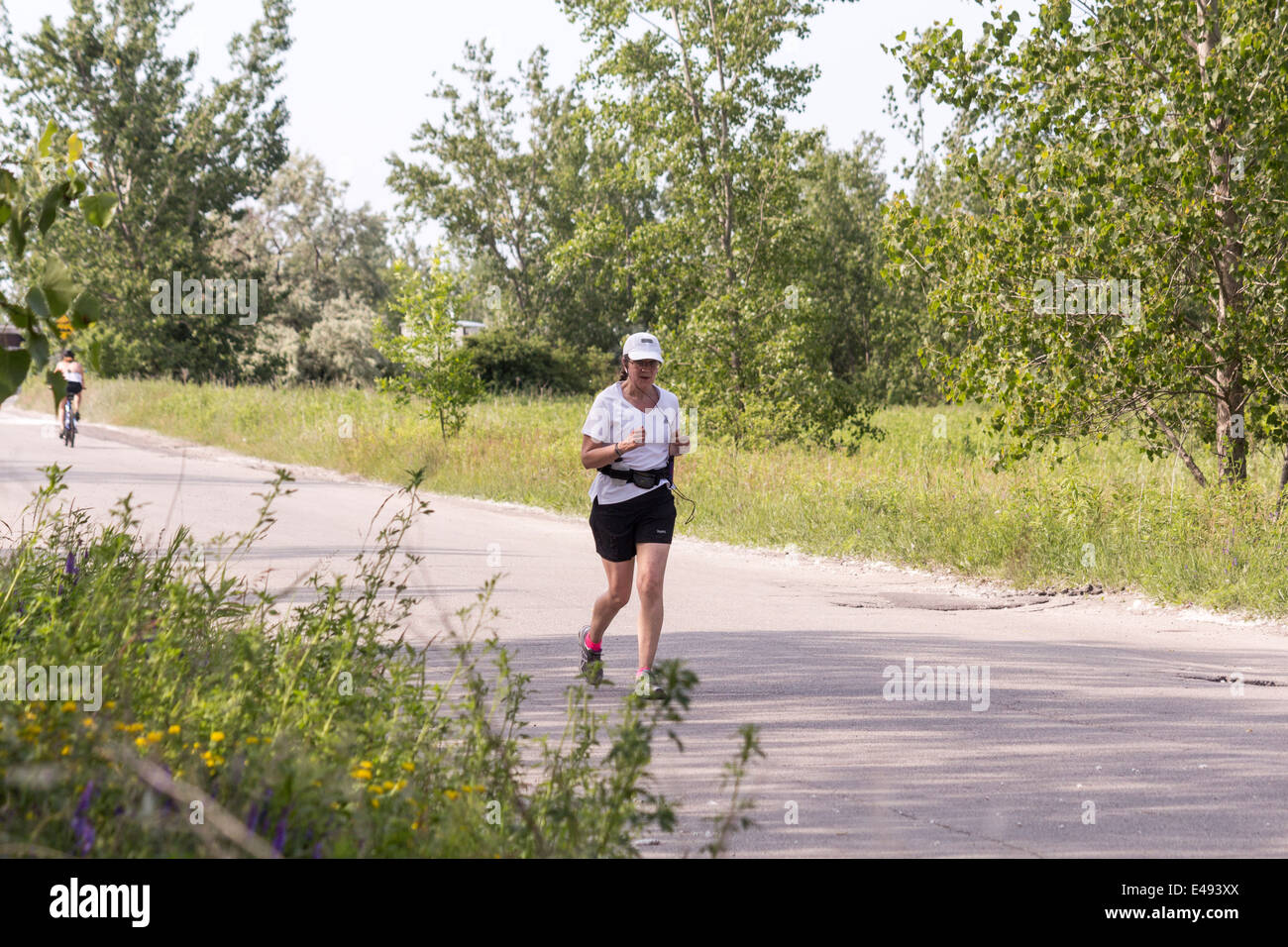 Femme plus âgée jogging dans la rue Leslie Spit ou Tommy Tompson Park à Toronto (Ontario) Banque D'Images