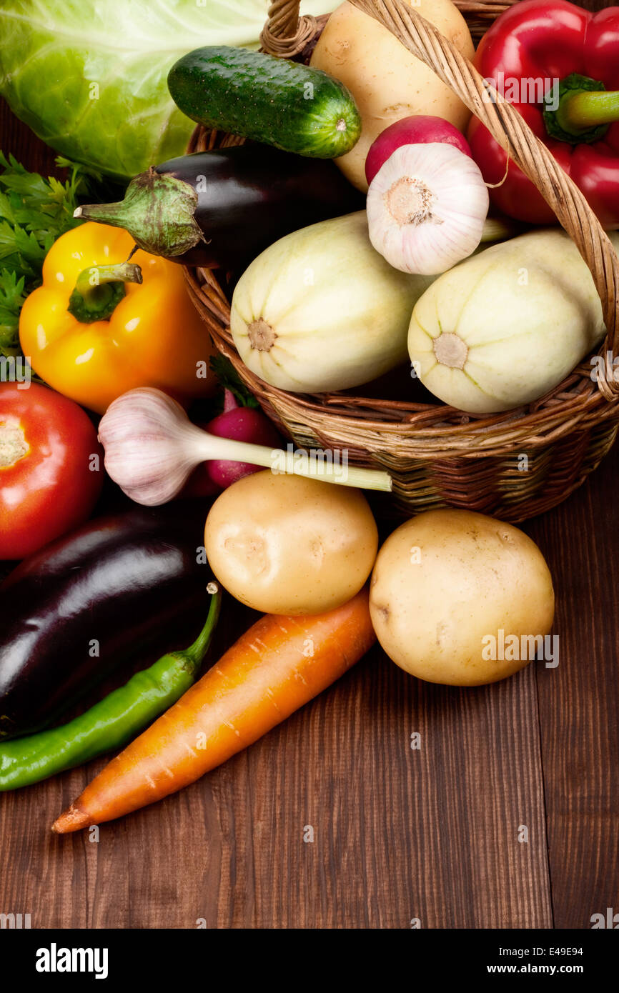 Les légumes frais mûrs dans un panier sur la table en bois Banque D'Images