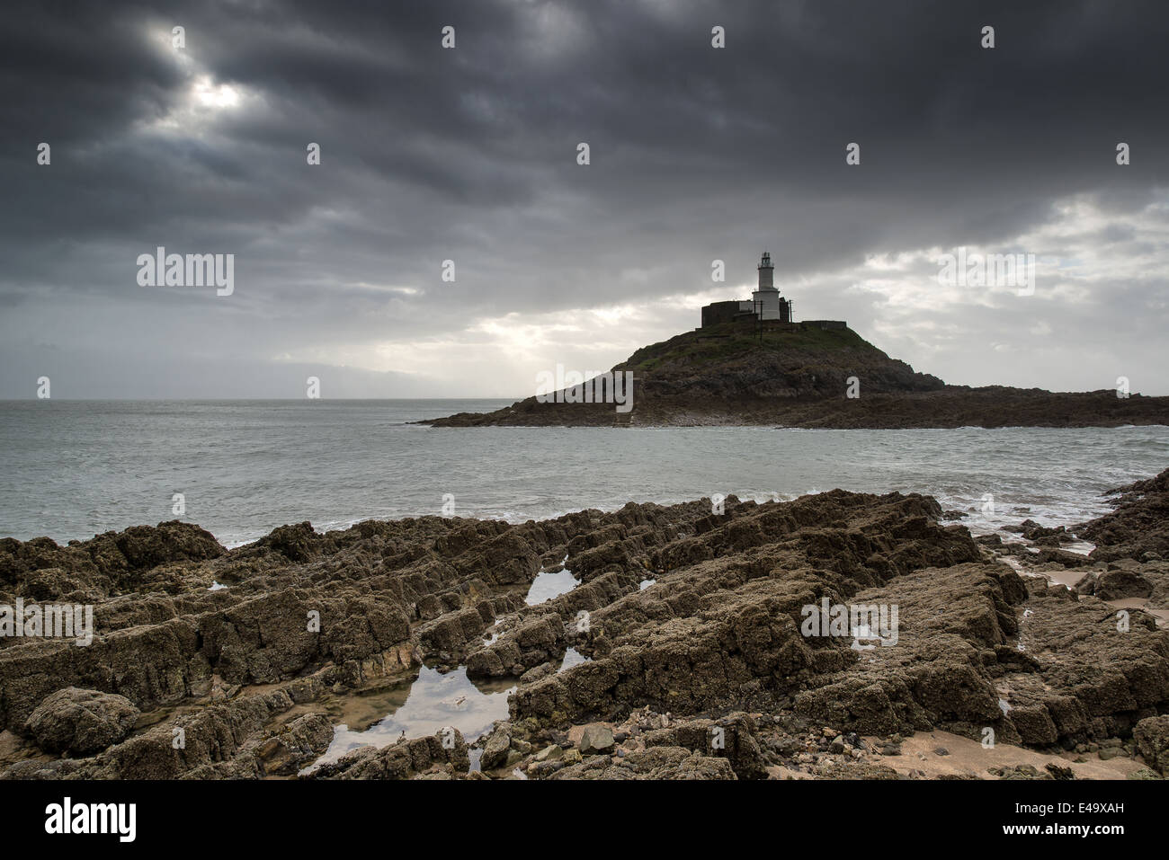 Phare de pointe avec des rayons de soleil sur l'océan paysage Banque D'Images