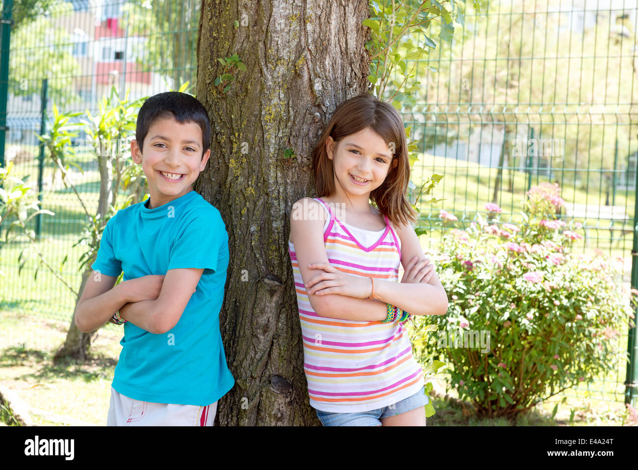 Les jeunes enfants posant près d'un arbre dans le parc Banque D'Images