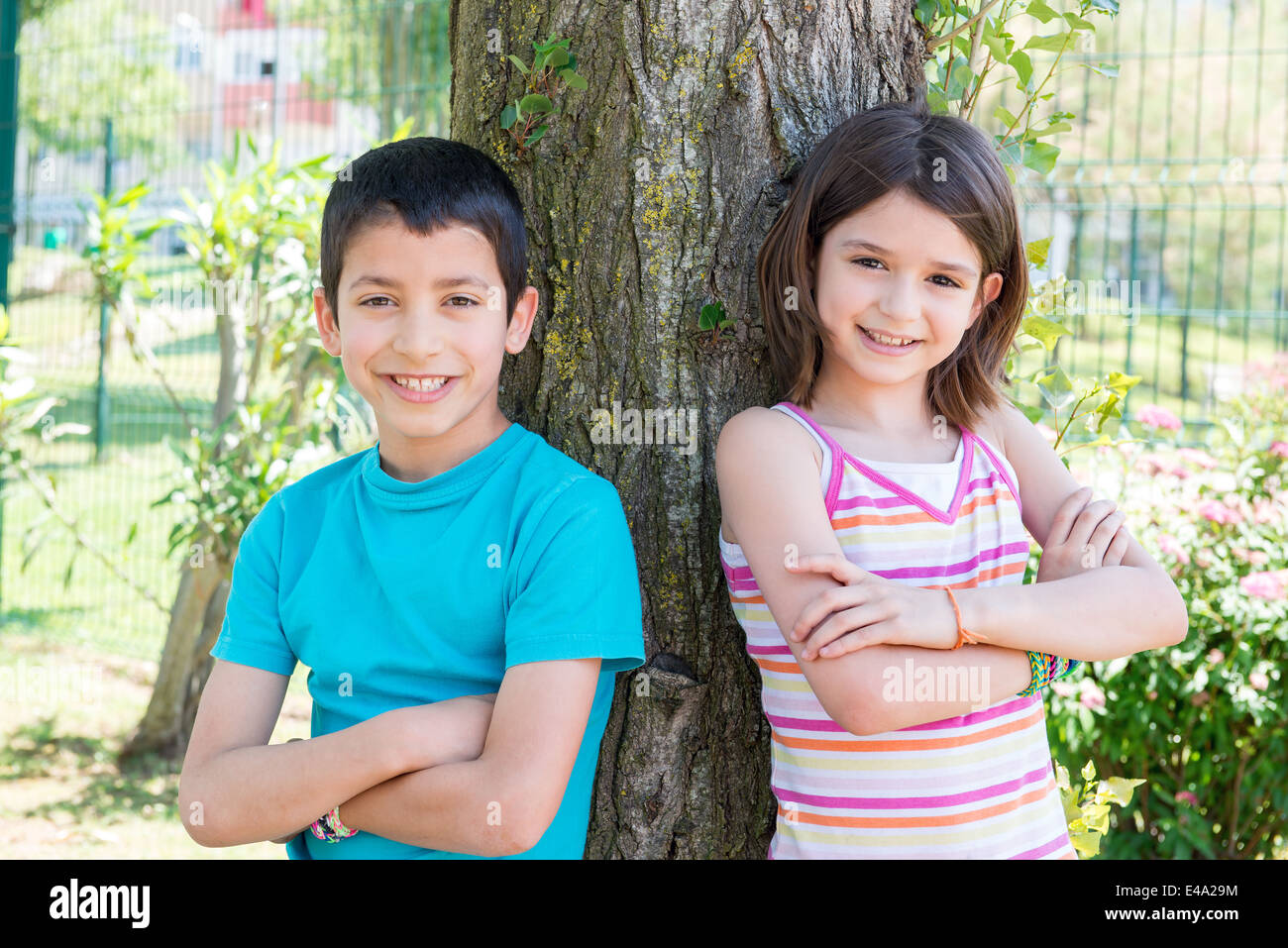 Les jeunes enfants posant près d'un arbre dans le parc Banque D'Images