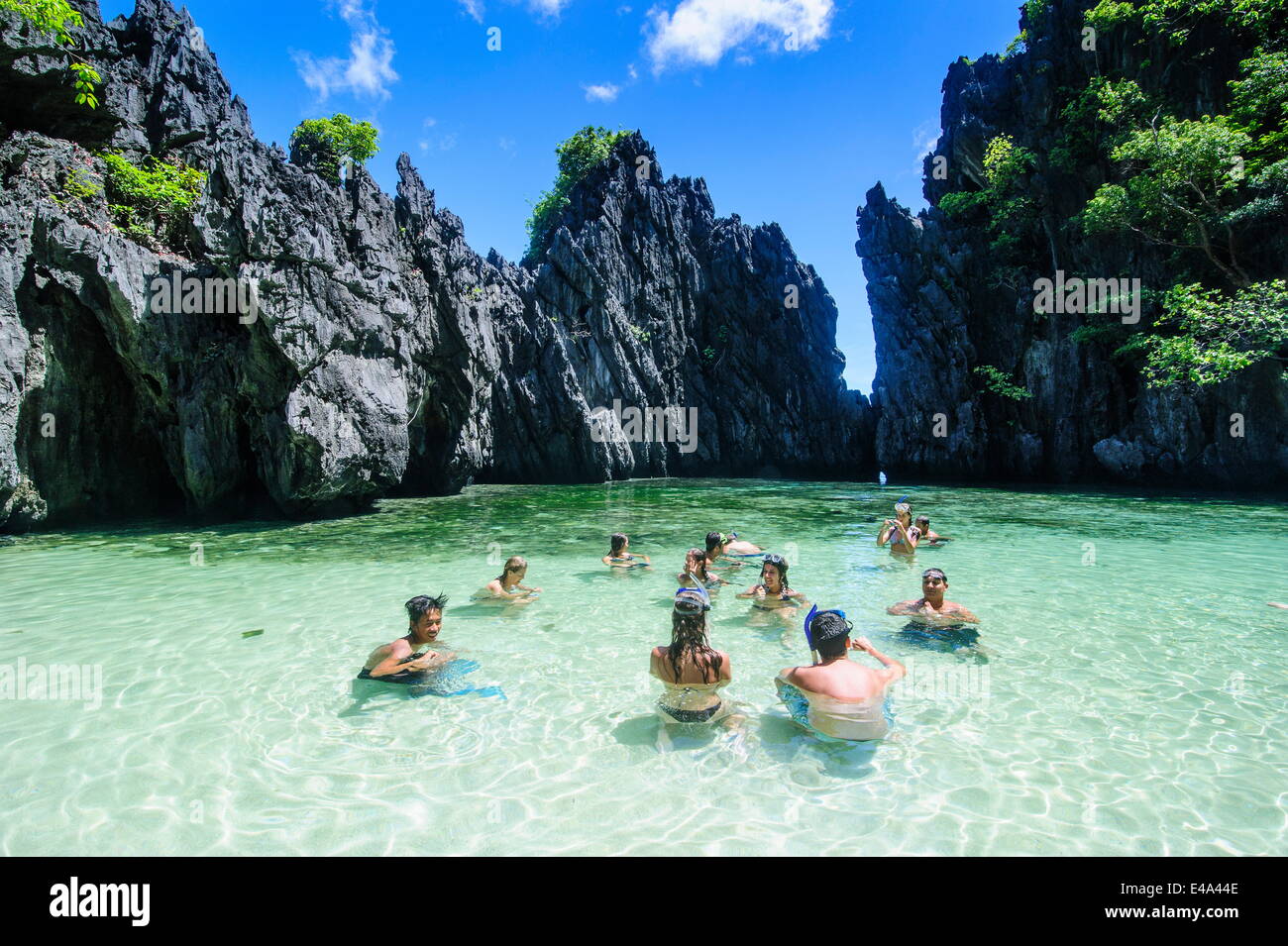 Les touristes dans la baie cachée avec de l'eau claire comme du cristal dans l'archipel de Bacuit, Palawan, Philippines, Asie du Sud, Asie Banque D'Images