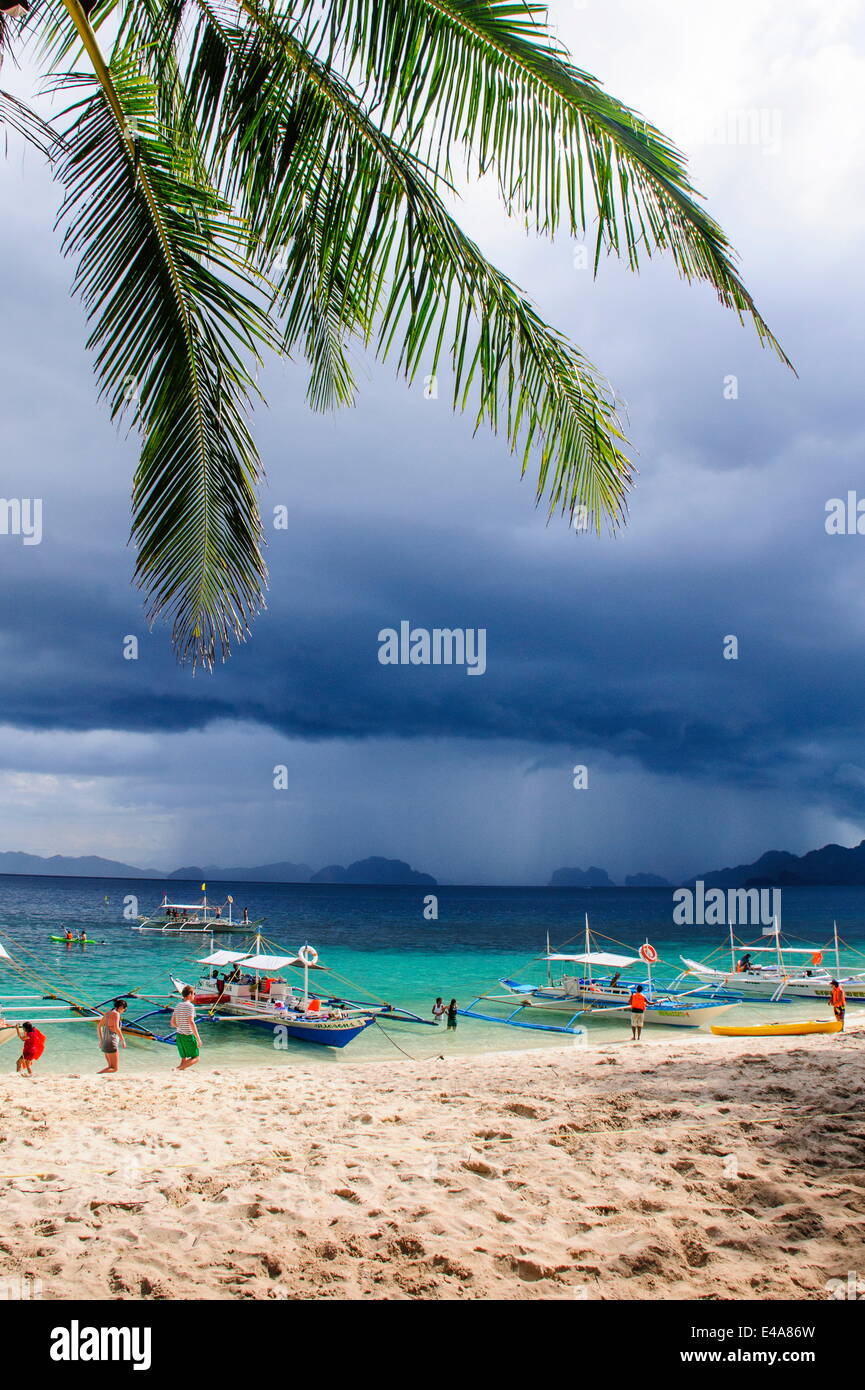 Outrigger avant qu'un ancrage strom bateaux sur une plage de sable à l'archipel Bacuit, Palawan, Philippines, Asie du sud-est Banque D'Images