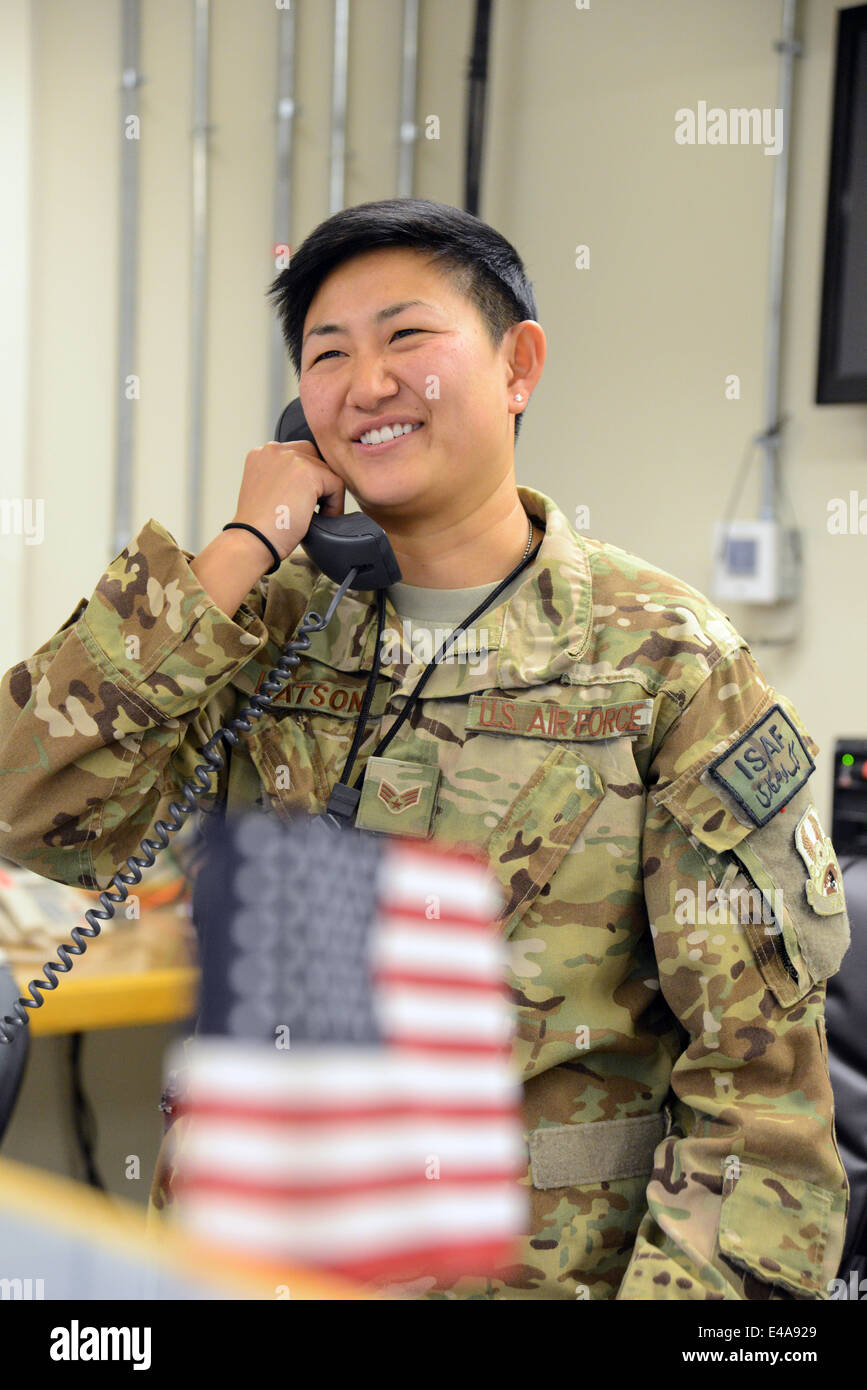 Les cadres supérieurs de l'US Air Force Airman Ashley Watson sourit pendant une conversation téléphonique avec le secrétaire à la défense Chuck Hagel pour marquer le Jour de l'indépendance américaine le 4 juillet à l'aérodrome de Bagram, en Afghanistan. Secrétaire Hagel a appelé un membre de chaque service sur la quatrième de juillet pour les remercier de leur service pendant le déploiement. Banque D'Images