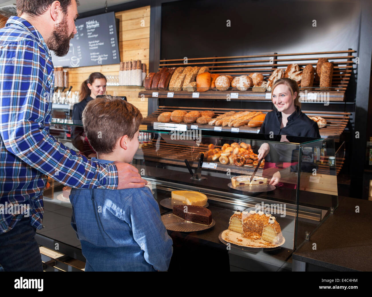 Père et fils l'achat de gâteaux dans une boulangerie bio Banque D'Images