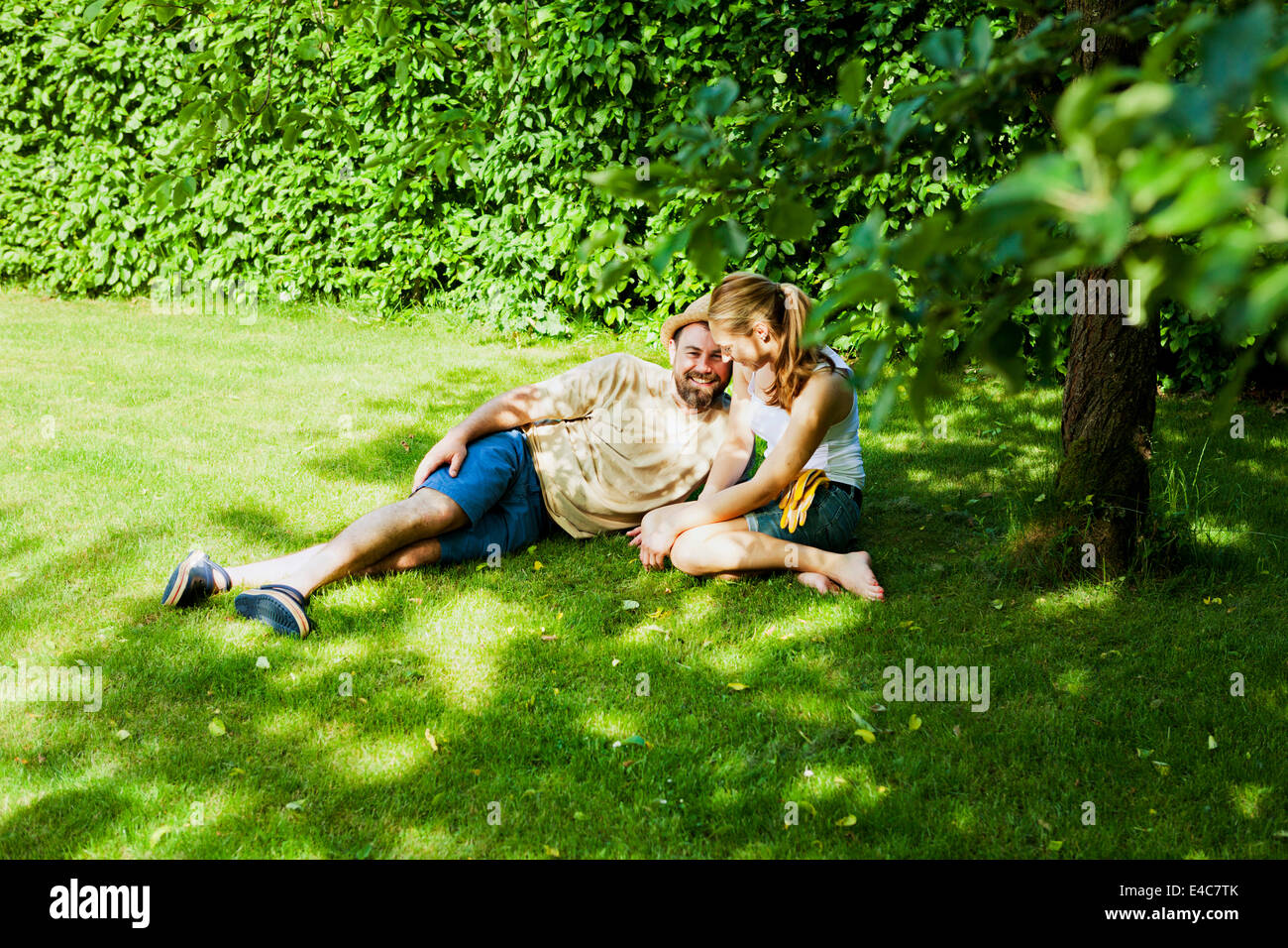 Couple hétérosexuel prend une pause dans le jardin, Munich, Bavière, Allemagne Banque D'Images