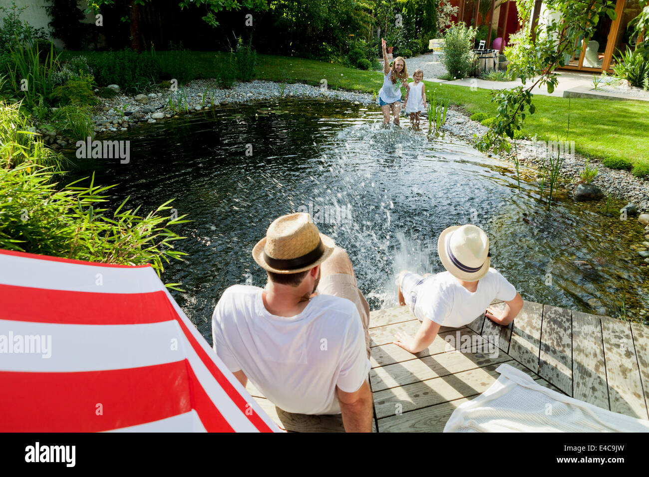 Imbéciles autour de la famille par l'étang, les projections d'eau, Munich, Bavière, Allemagne Banque D'Images