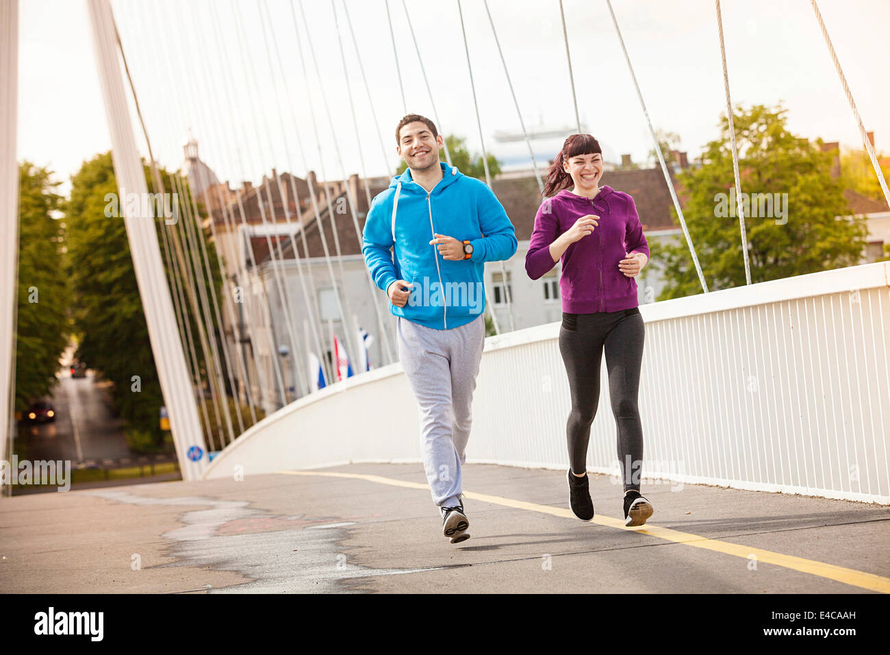 Jeune couple jogging sur le pont, Osijek, Croatie Banque D'Images
