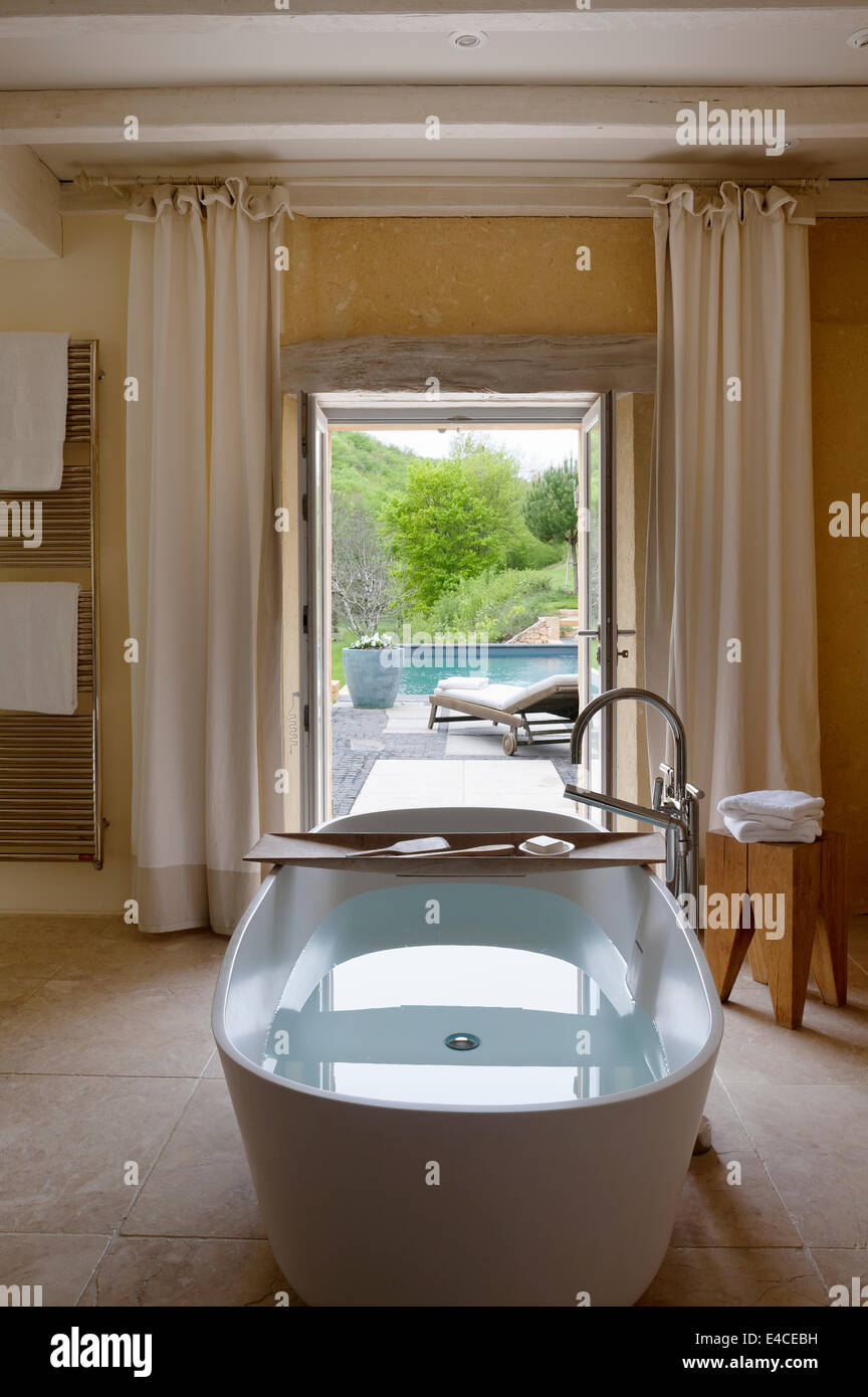 Une profonde baignoire 910 AV de l'agapè dans la salle de bains avec entrée  et jardin avec vues Photo Stock - Alamy