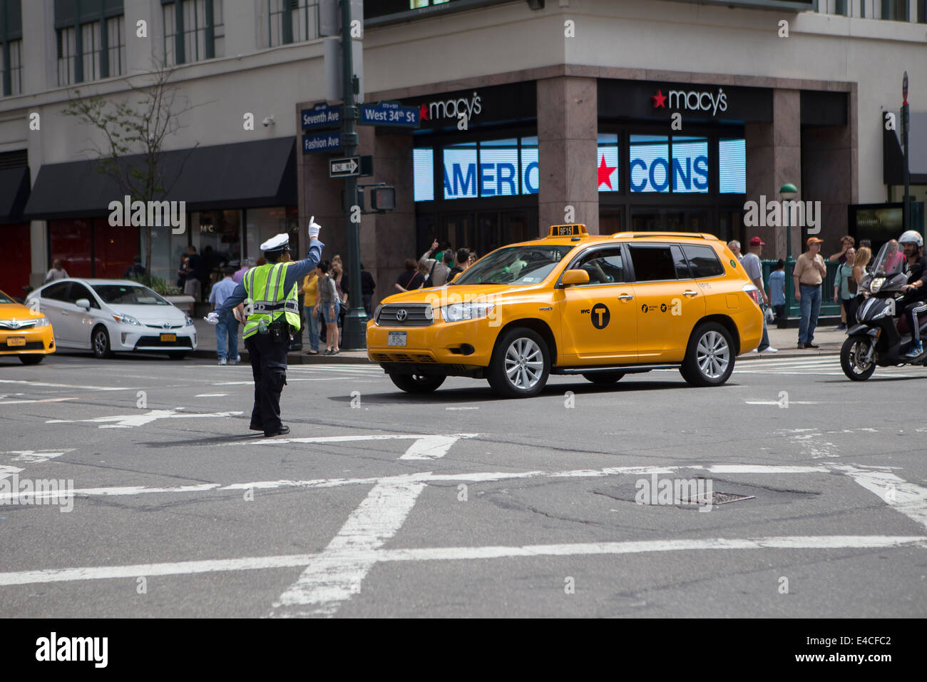 Une femme de police dirige le trafic à une intersection achalandée à New York, NY Banque D'Images