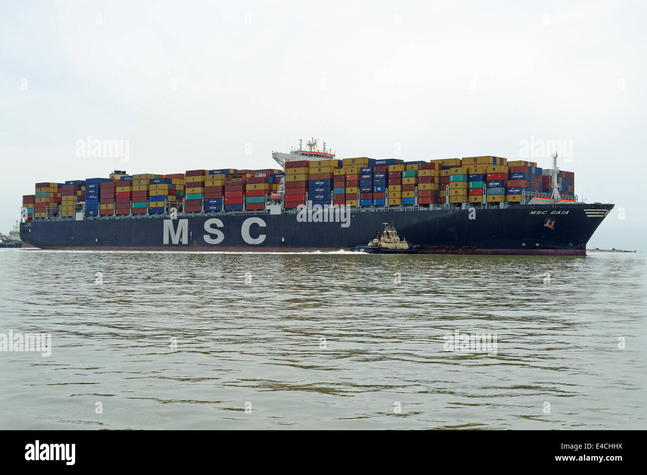 Les 151 000 tonnes de navires porte-conteneurs MSC Gaia être manoeuvré à l'aide de remorqueurs dans le terminal à conteneurs de Felixstowe (Royaume-Uni). Banque D'Images