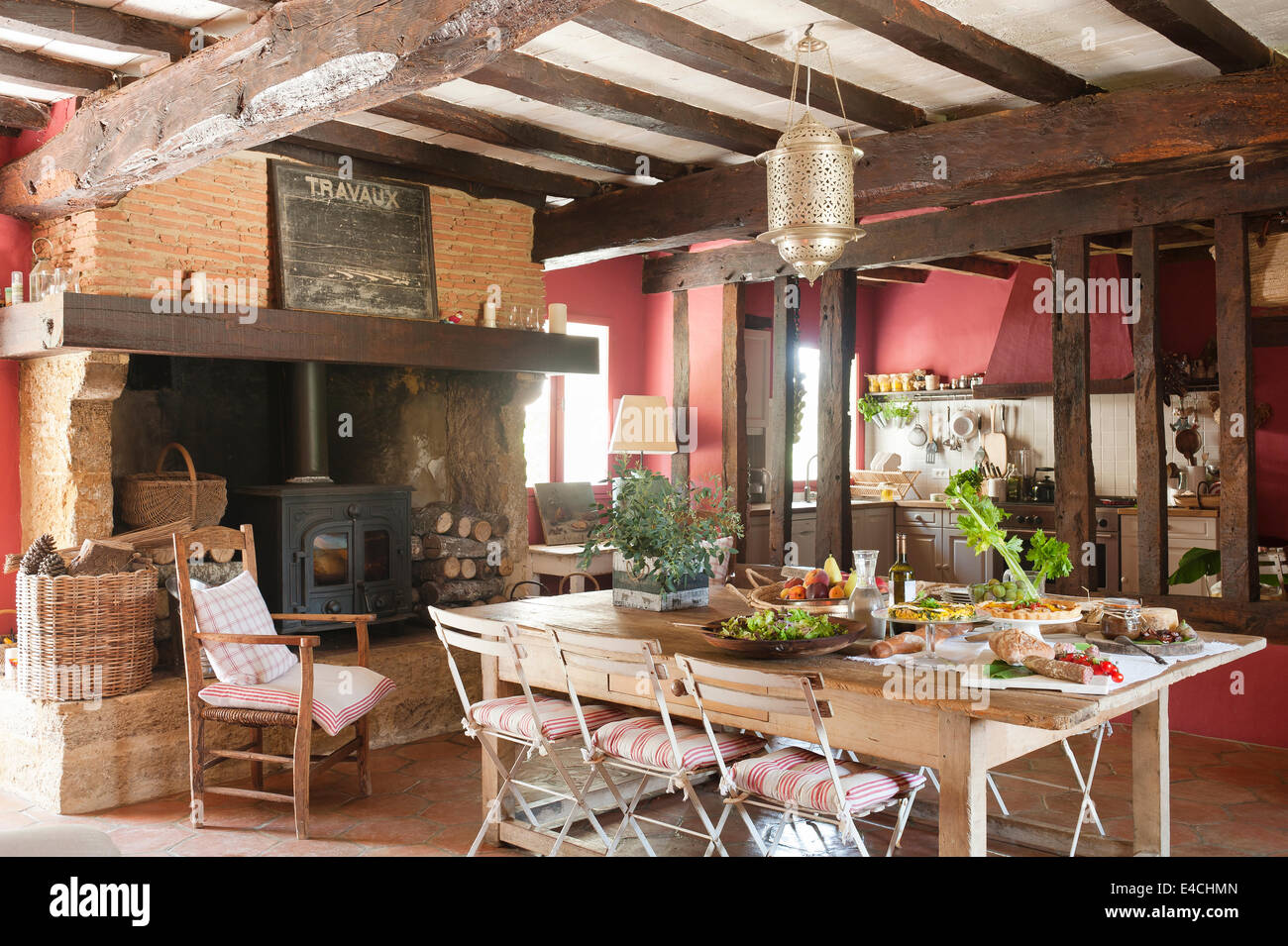 Grande cuisine rustique pays français avec de vieilles poutres apparentes, poêle à bois et table Banque D'Images