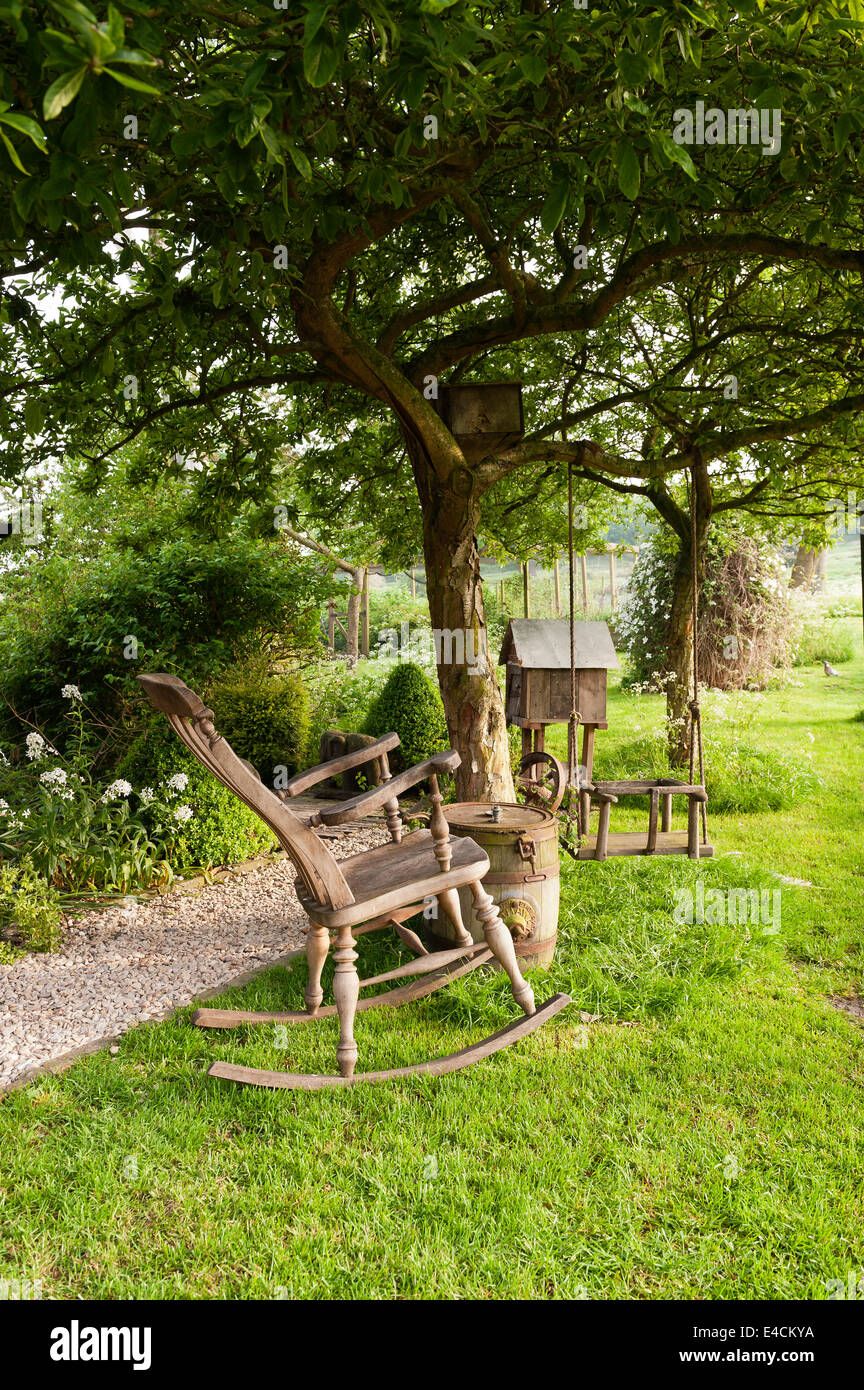 Fauteuil à bascule en bois et swing en jardin de chalet Banque D'Images