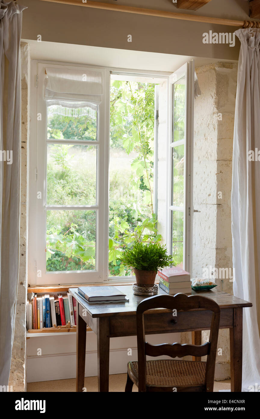 Table en chêne français et chaise antique par fenêtre avec vue sur le jardin Banque D'Images
