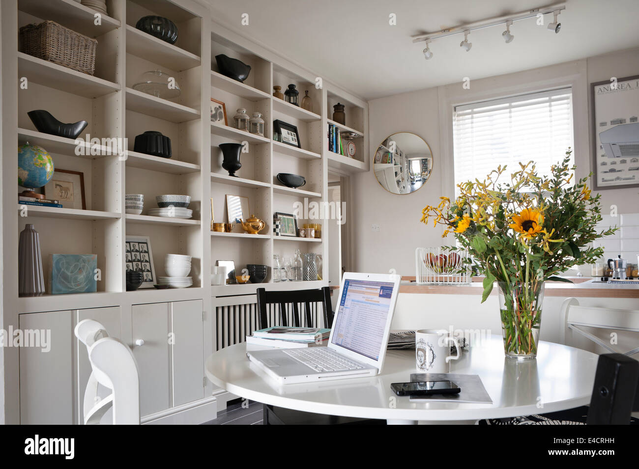 Ordinateur portable sur la table ikea blanc en cuisine ouverte et salle à  manger avec des rayonnages ouverts et miroir convexe Photo Stock - Alamy