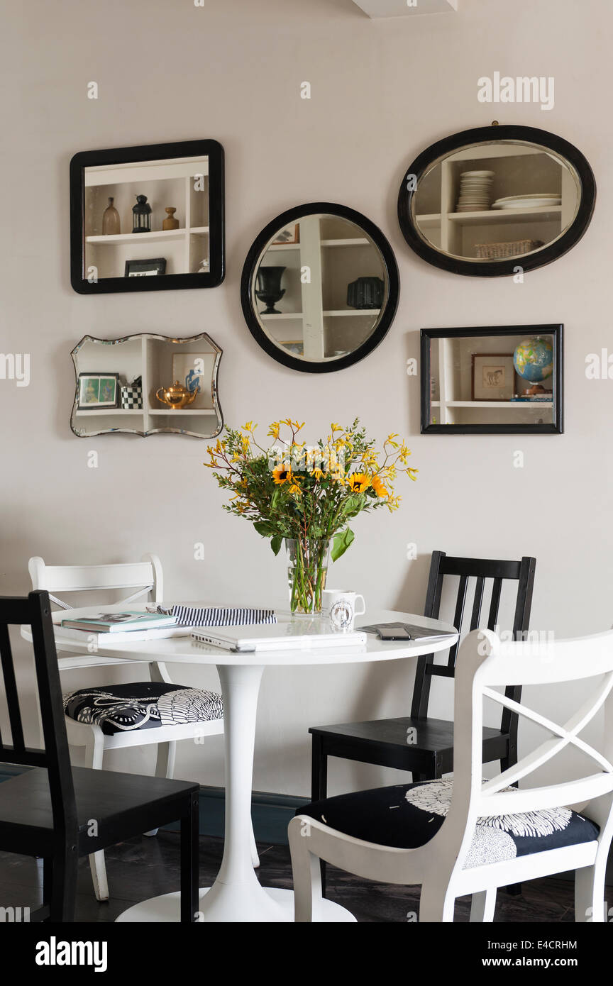 Ikea table à manger et chaises noires en repas avec collection de miroirs en bois vintage du vendeur d'arachides Banque D'Images