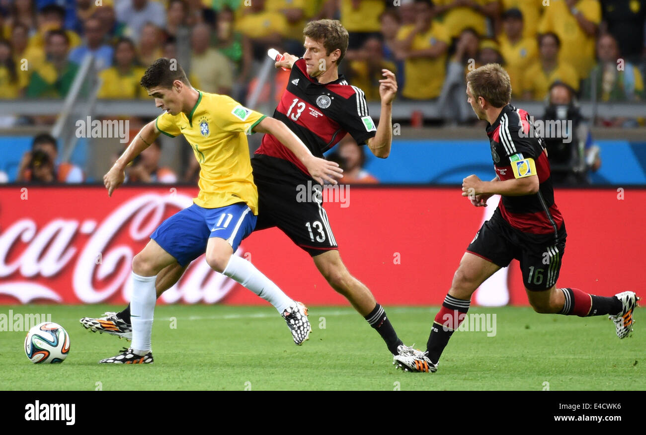 Belo Horizonte, Brésil. 8 juillet, 2014. L'Allemagne Thomas Muller (C) rivalise avec Oscar du Brésil (L) au cours d'un match de demi-finale entre le Brésil et l'Allemagne de la Coupe du Monde FIFA 2014 à l'Estadio Stade Mineirao de Belo Horizonte, Brésil, le 8 juillet 2014. L'Allemagne a gagné 7-1 sur le Brésil et s'est qualifié pour la finale de mardi. Crédit : Li Ga/Xinhua/Alamy Live News Banque D'Images