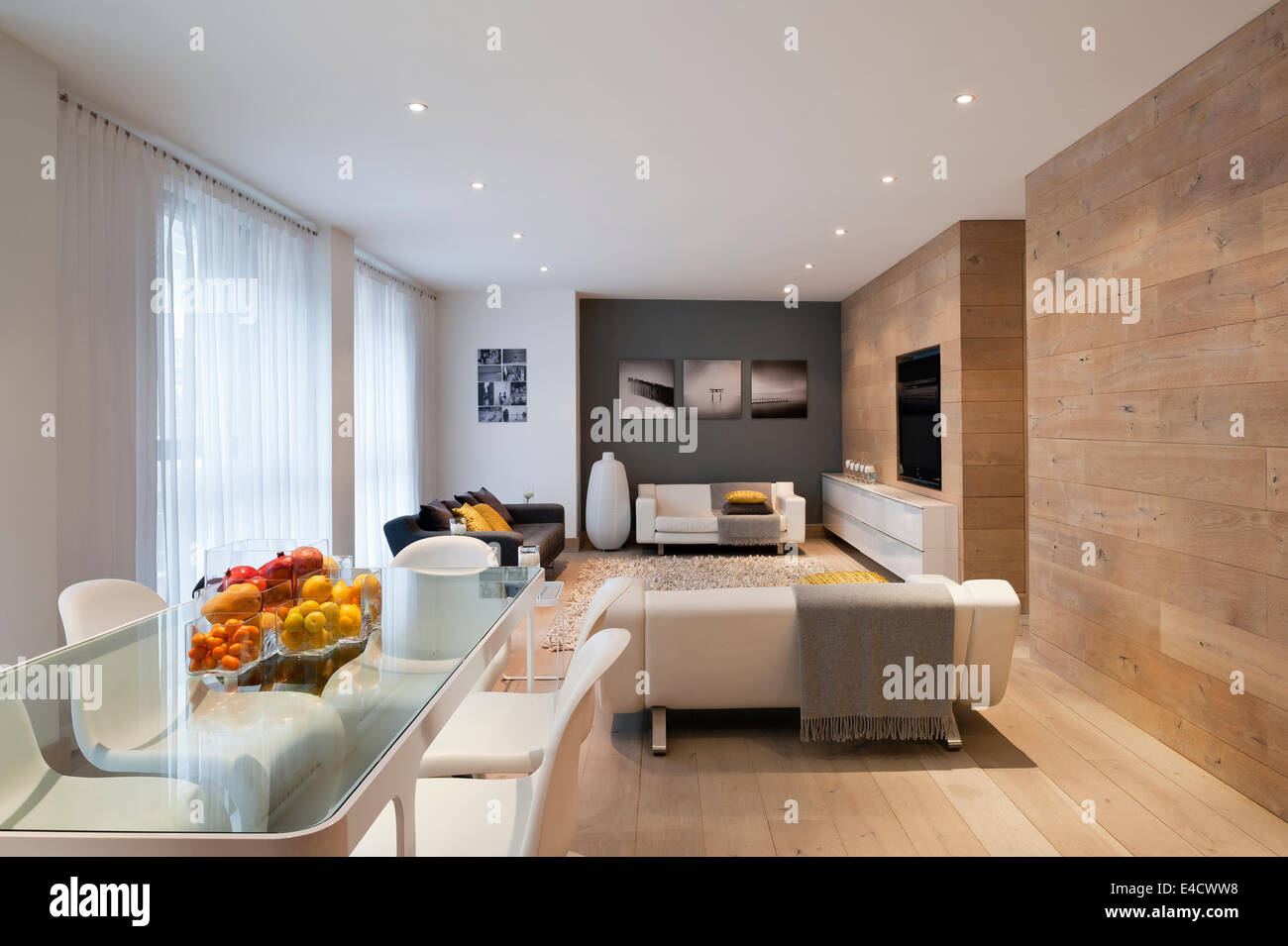 Savonnées blanc chêne français utilisé pour les revêtements de sol et murs dans un salon spacieux. La tête de verre table à manger est tracé à partir de Banque D'Images