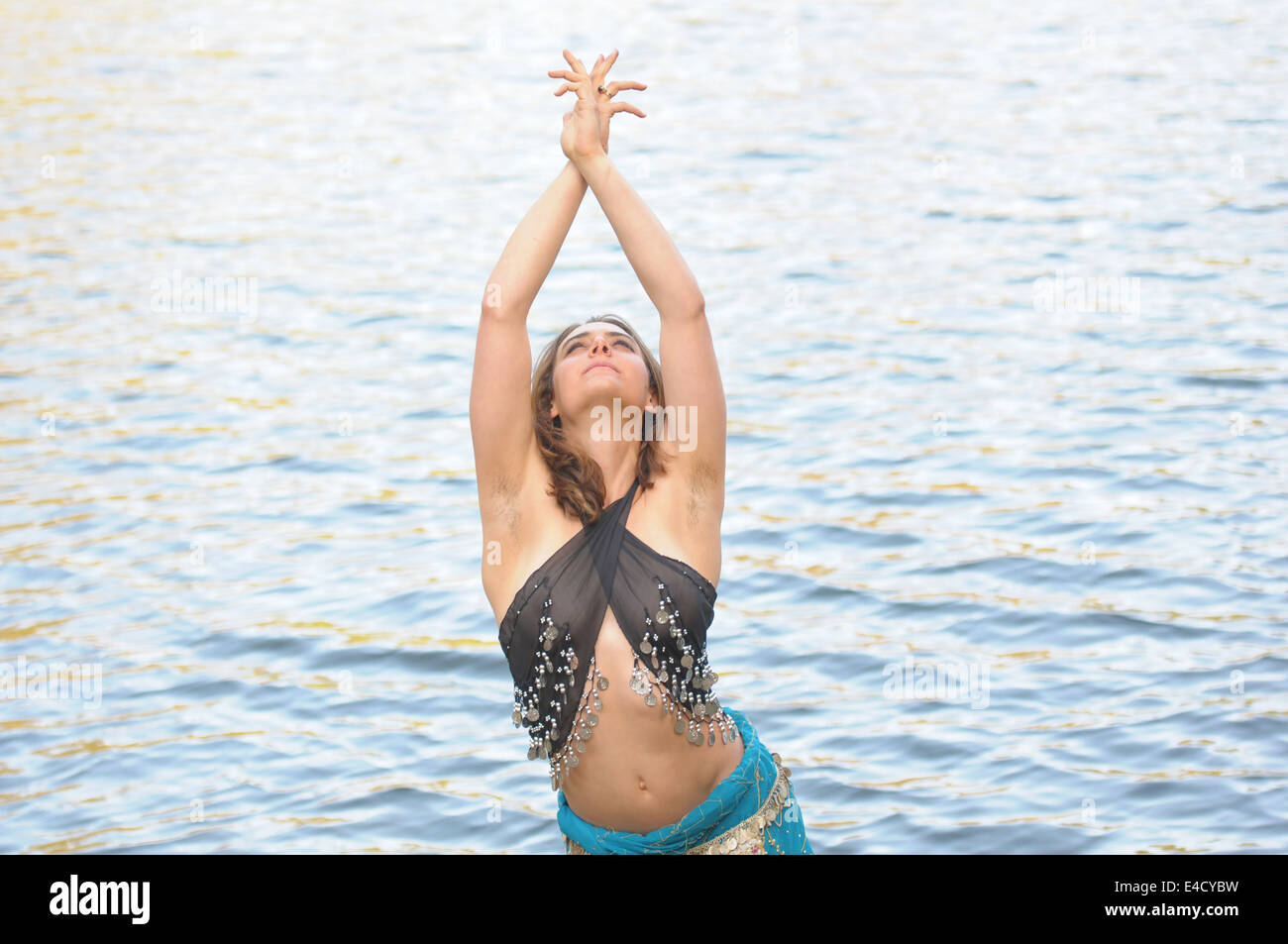 Une danseuse du ventre, posant près de l'eau portant un voir par le dessus. Banque D'Images