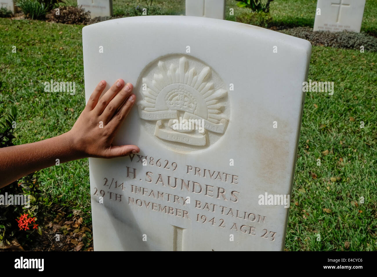 Une main caresse la mémoire du soldat autochtone australien, Harry Saunders à Bomana Cimetière de guerre à Port Moresby, PNG Banque D'Images