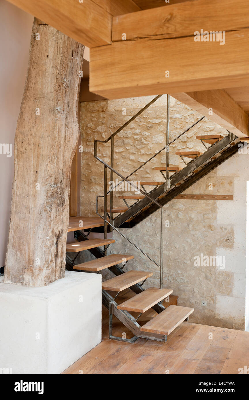 Le métal galvanisé escalier avec marches en bois conçu par Jeremy Harris dans ancienne grange avec murs en pierre et bois d'origine Banque D'Images
