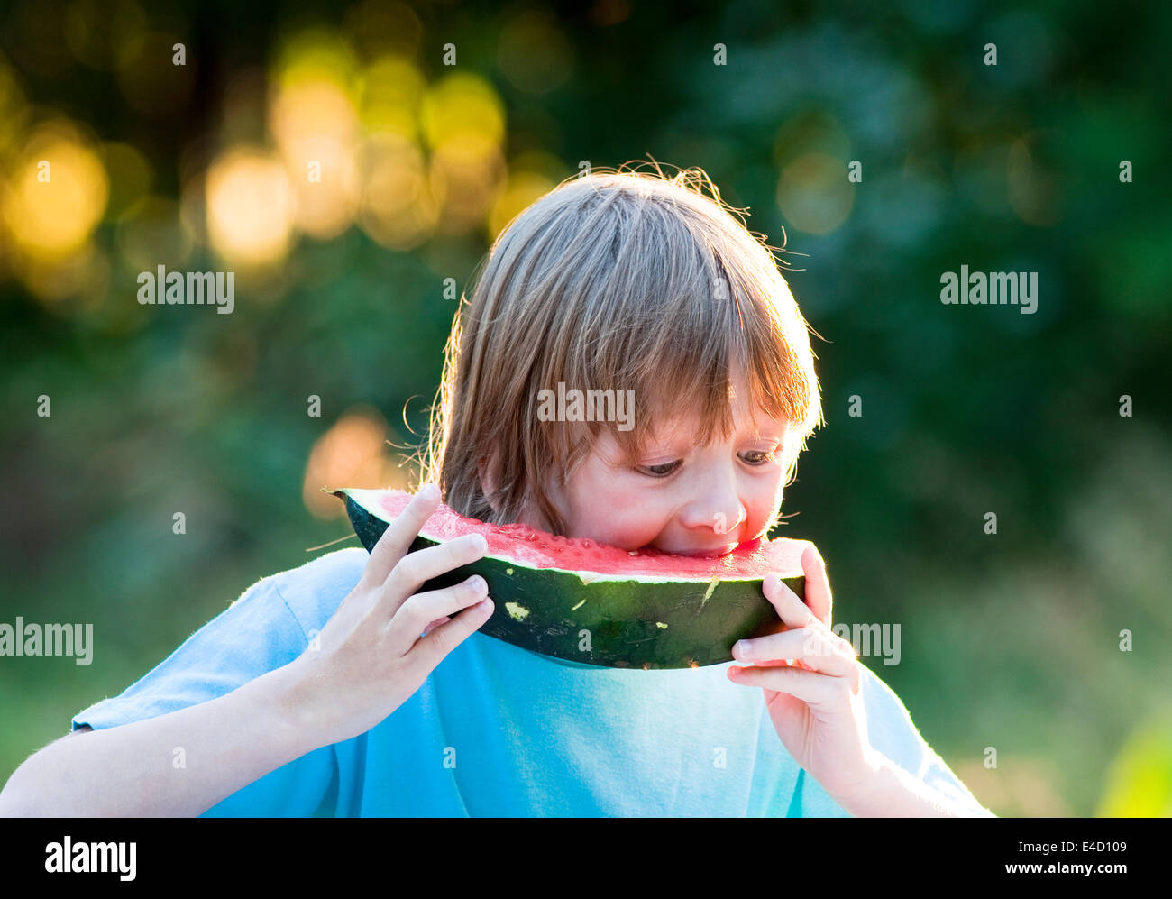 Boy Eating Watermelon Outdoors Banque D'Images