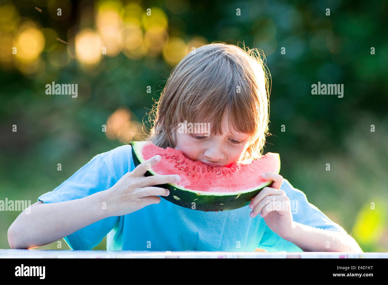 Boy Eating Watermelon Outdoors Banque D'Images