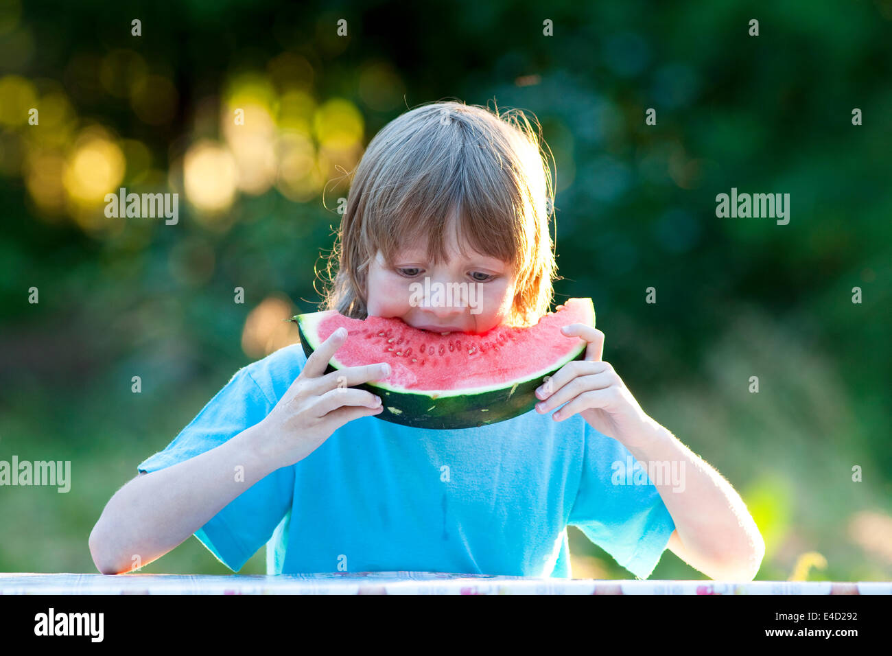 Boy Eating Watermelon Outdoors Banque D'Images