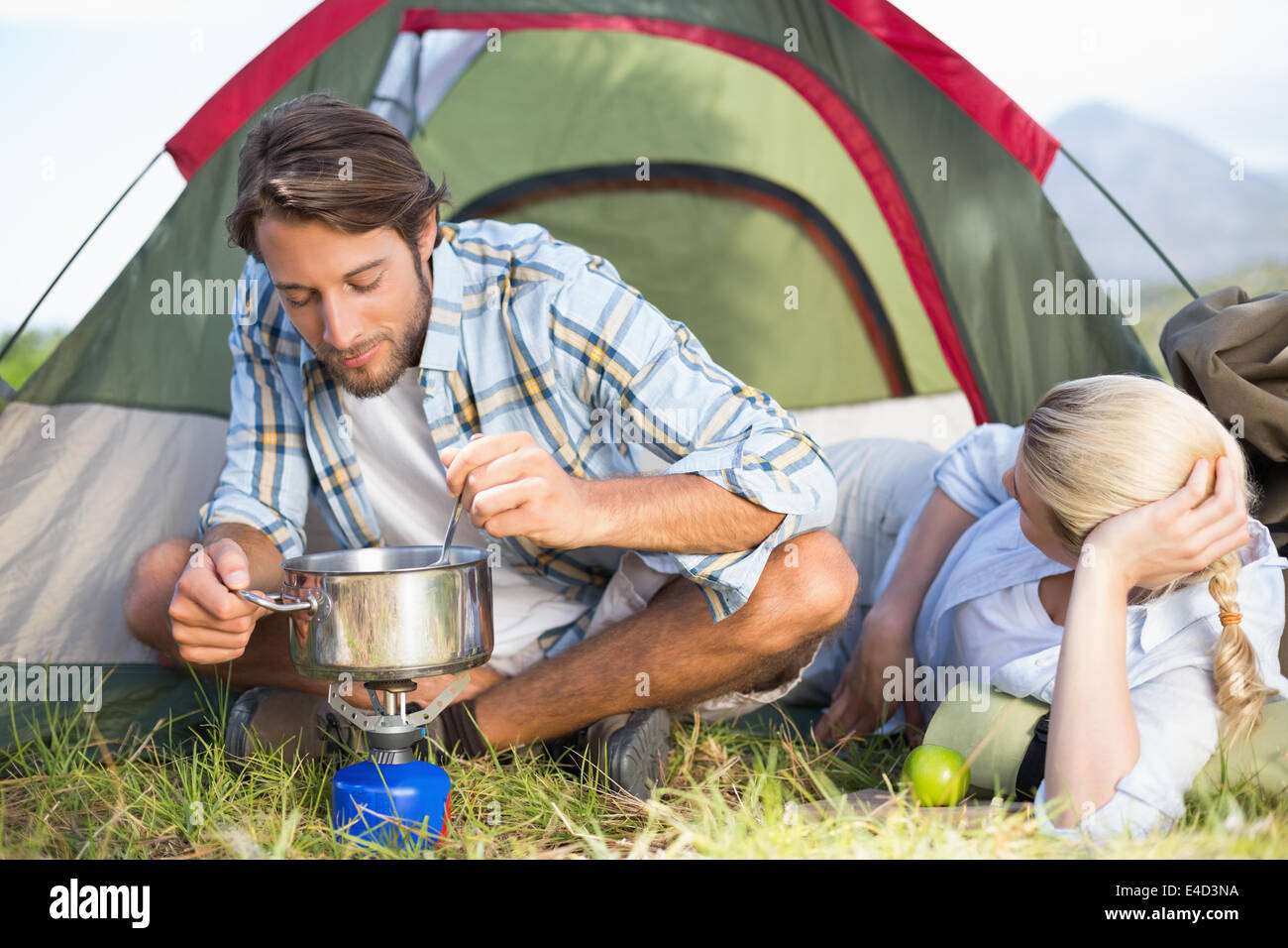 Joli couple heureux sur la cuisine cuisinière camping Banque D'Images