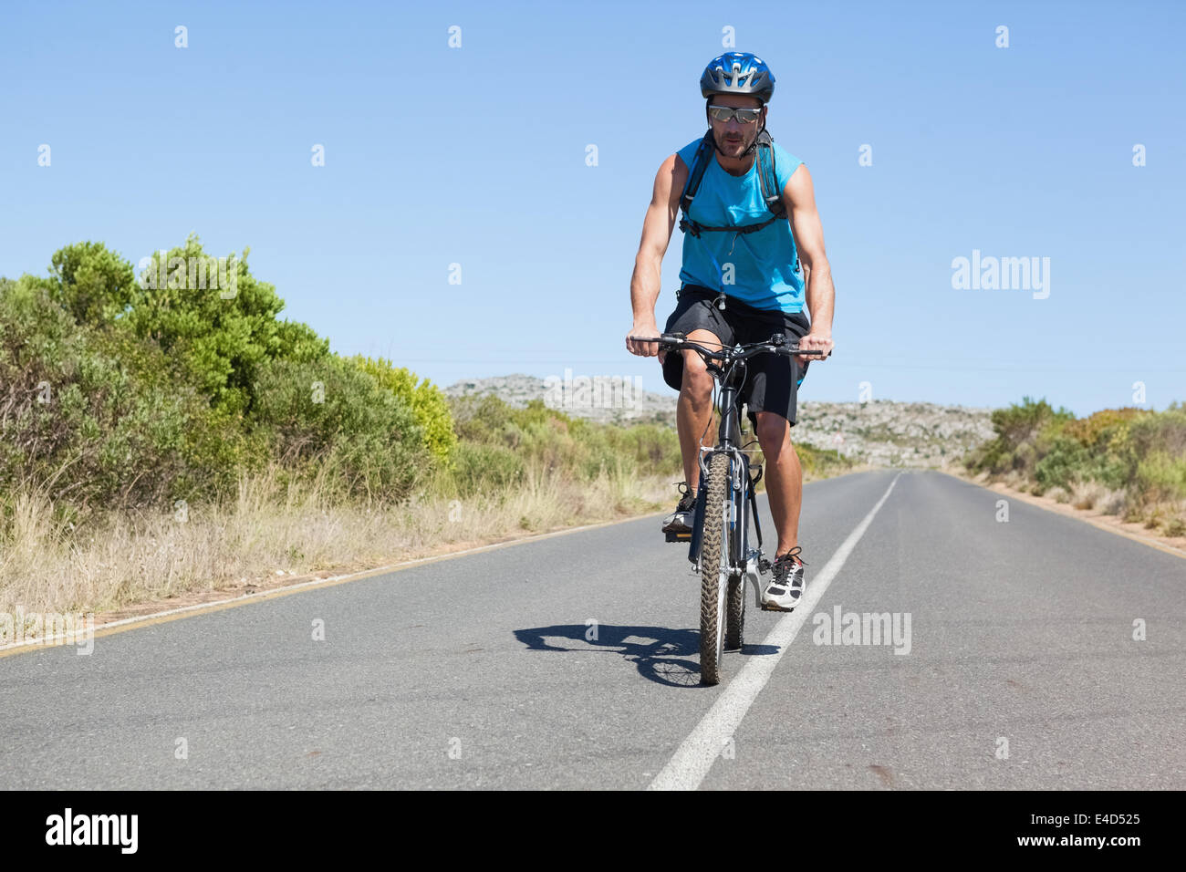 L'homme athlétique vélo sur route ouverte Banque D'Images