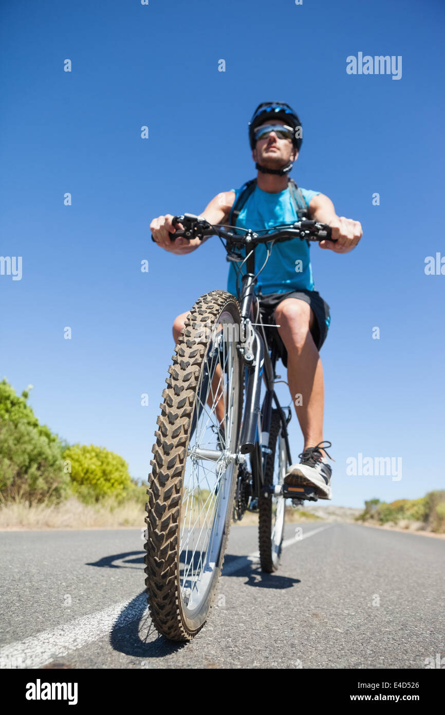 L'homme athlétique vélo sur route ouverte Banque D'Images