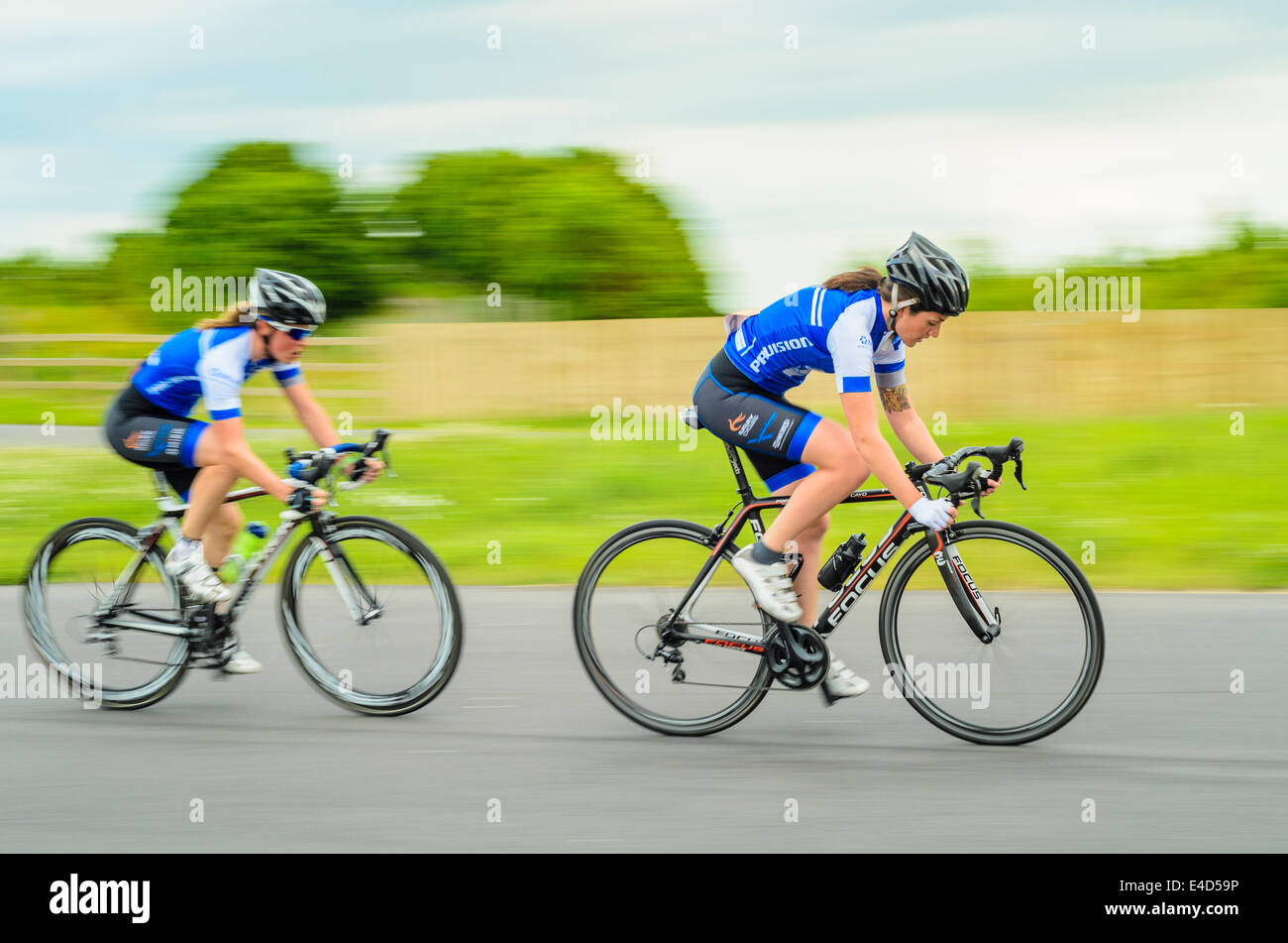 Les cyclistes de compétition au critérium de la femme sur l'événement du circuit du cycle dédié à York York Yorkshire Village Sport Banque D'Images Les cyclistes de compétition au critérium de la femme sur l'événement du circuit du cycle dédié à York York Yorkshire Village Sport Banque D'Images