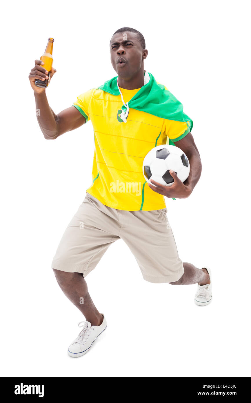 Heureux fan de football brésilien holding ball et la bière Banque D'Images