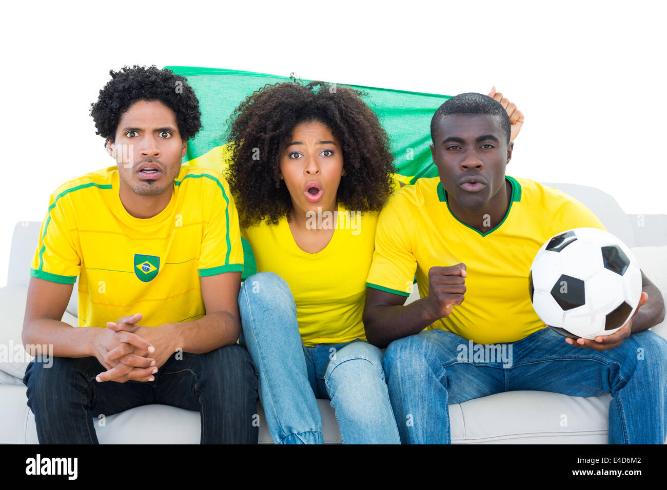 Heureux les fans de football en jaune assis sur table avec le drapeau du Brésil Banque D'Images