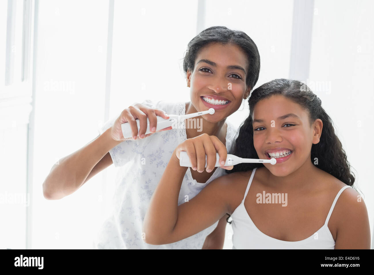 Jolie mère se brosser les dents avec sa fille Banque D'Images