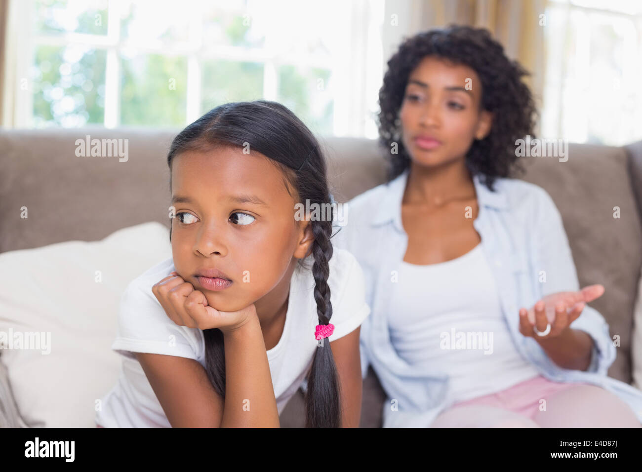 Jolie mère assis sur table après une dispute avec sa fille Banque D'Images
